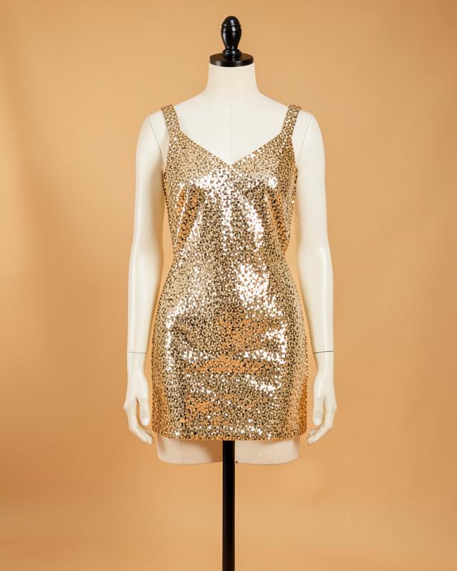 Vestido curto dourado de paetê em manequim